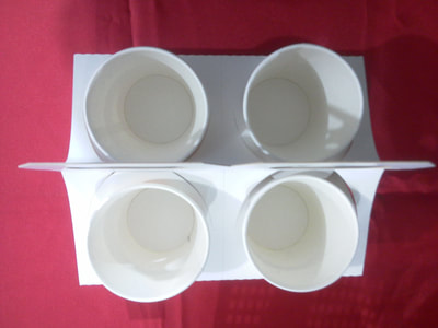 Top view of four paper cups inside an adjustable paper cup holder